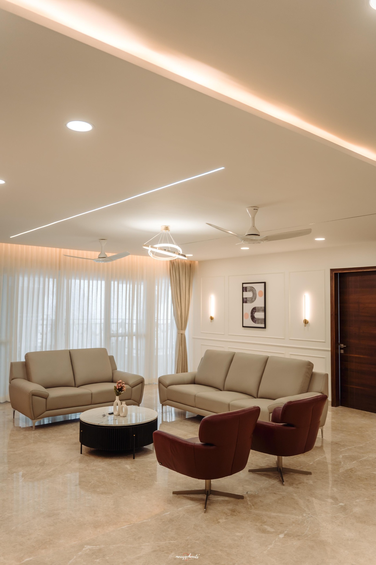Formal living room with leather sofas, burgundy swivel chairs and cove lighting