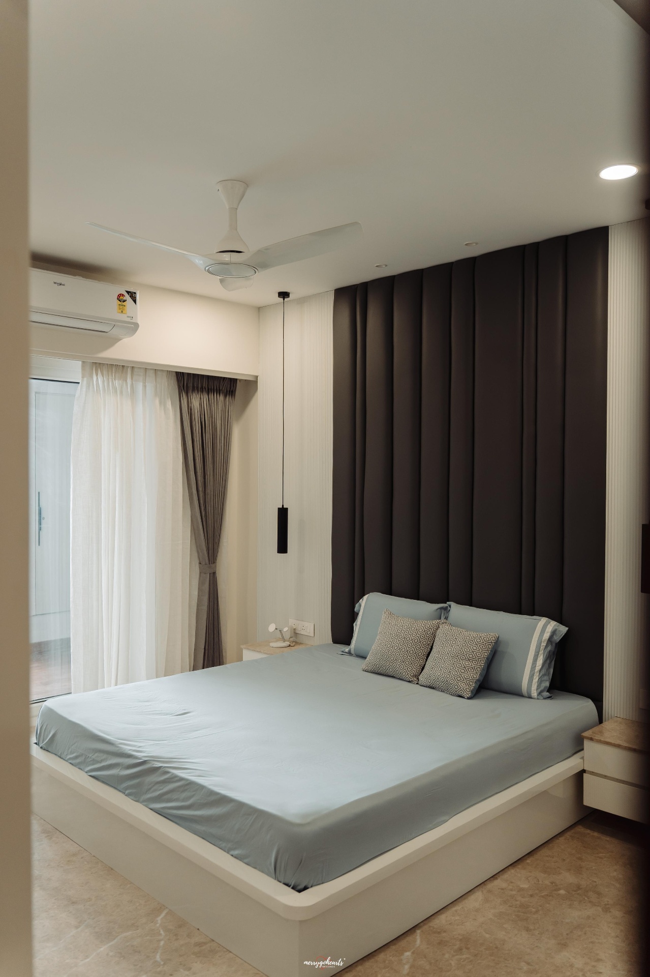 Bedroom with a charcoal channel-tufted wall panel and fluted side panelling