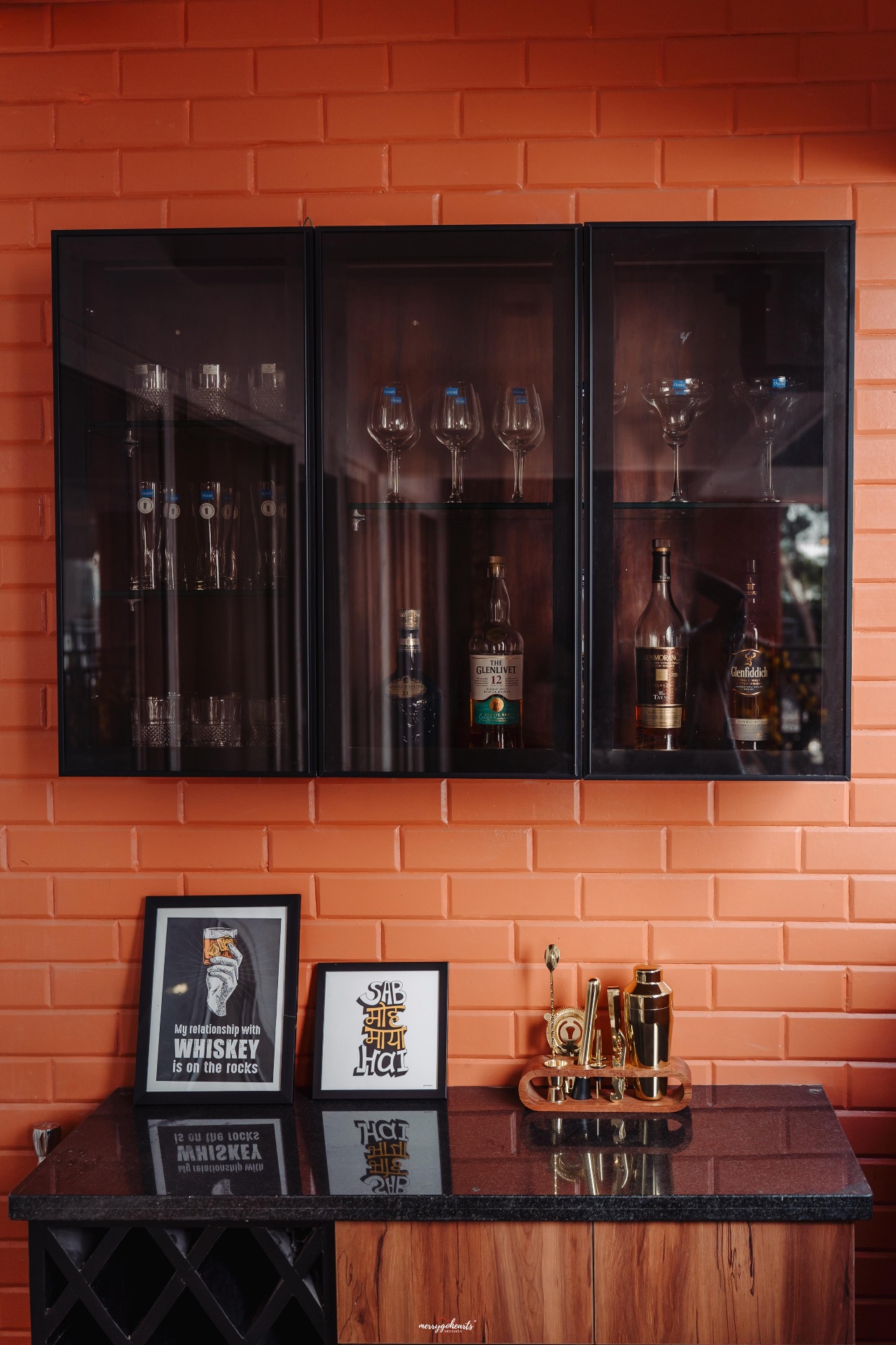 Bar unit with terracotta exposed-brick wall, glass display cabinets and granite counter