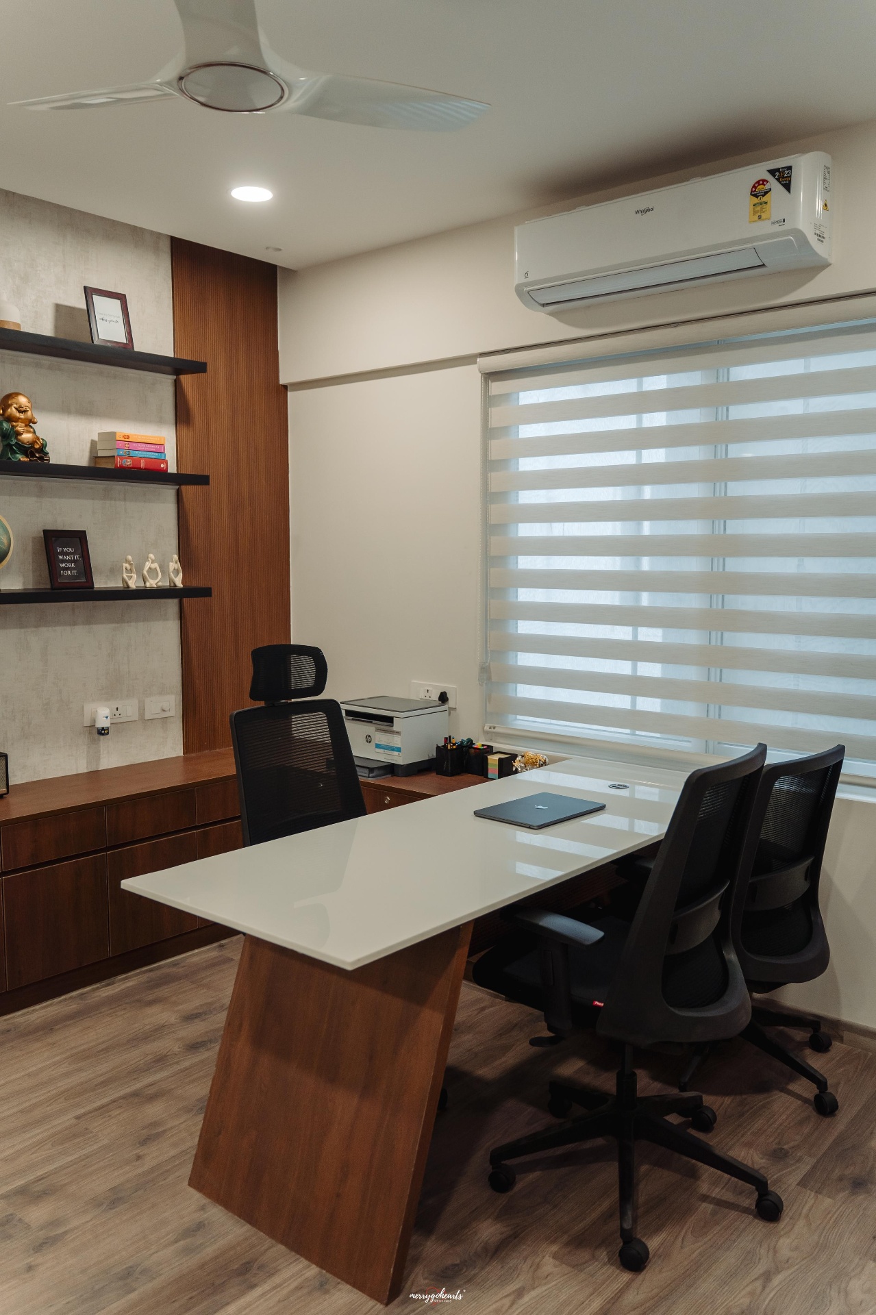 Home office with wood panelling, floating shelves and a glass-top desk